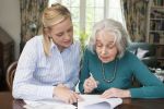 Woman Helping Senior woman With Paperwork